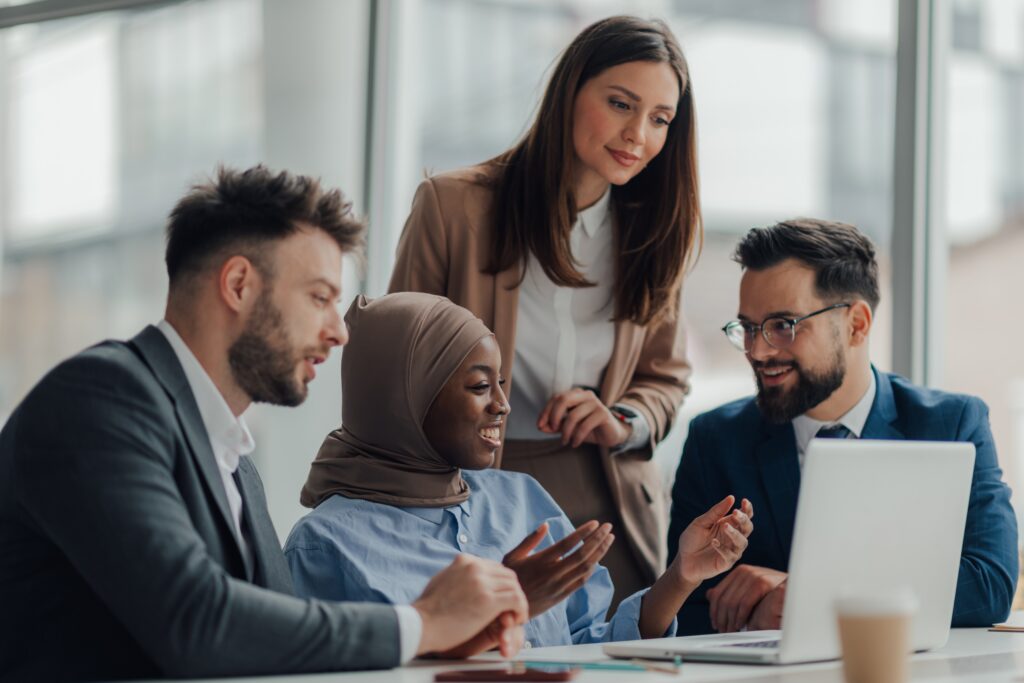 Diverse group gathered around a computer for watch training program