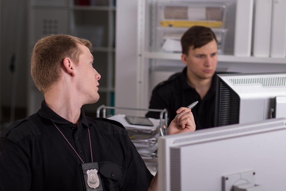 Two,Handsome,Police,Officers,Sitting,Beside,Computers,At,The,Police